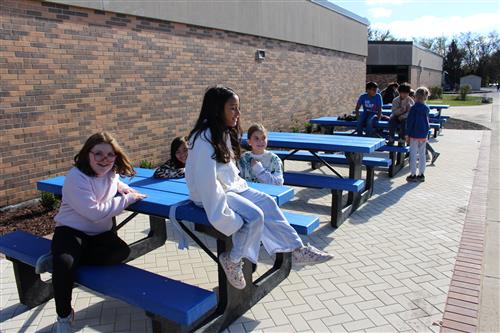 Kids sitting at picnic benches